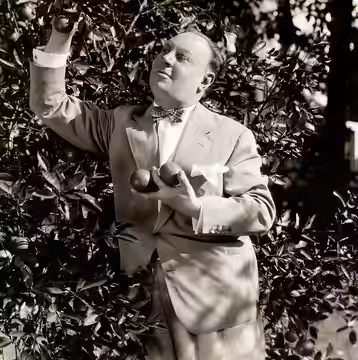 Omschrijving: Acteur Emil Jannings plukt elke morgen voor zijn ontbijt enkele sinaasappels uit zijn eigen tuin achter zijn landgoed in Hollywood. Foto uit 1929.