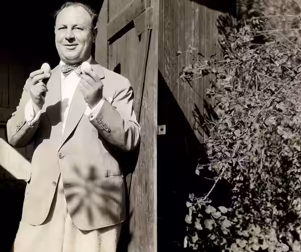 Omschrijving: Acteur Emil Jannings raapt elke morgen enkele eieren van zijn kippen, die hij in zijn riante tuin achter zijn landgoed in Hollywood houdt. Foto ui (1929)