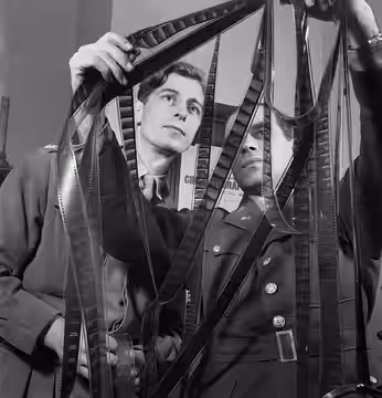 Colonel Frank Capra (right) of the US Army Signal Corps confers with Captain Roy Boulting of the British Army Film Unit on the editing of the film 'Tunisian Vic (1944)