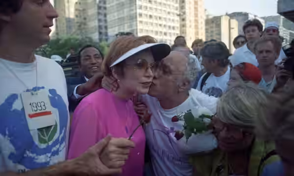 A atriz Shirley MacLaine recebe um beijo surpresa do Beijoqueiro durante evento da Rio-92. Foto de Chiquito Chaves, publicada por O Globo.