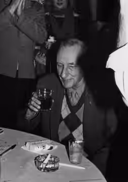 William Burroughs enjoying cake and alcohol at his 70th birthday. (1983)