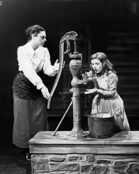 Photo of Anne Bancroft as Annie Sullivan and Patty Duke as Helen Keller in the broadway play The Miracle Worker. In this scene, Miss Sullivan tries to teach Hel