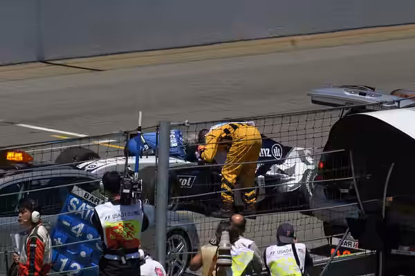 Ralf Schumacher is attended to by Gary Hartstein after impacting the wall out the outside of turn 12 on lap 9 of the 2004 United States Grand Prix.