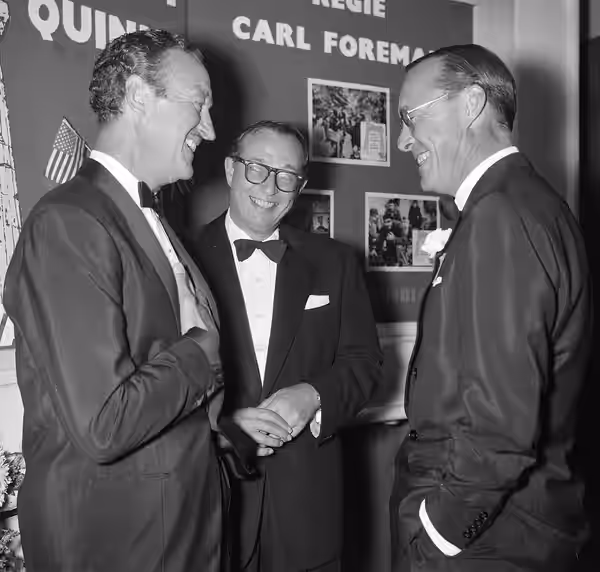 Prins Bernhard woont galavoorstelling van de film "The Guns of Navarone" bij. David Niven (links), Carl Foreman (scenarioschrijver) en prins Bernhard (1961)