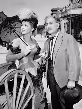 Photo of Amanda Blake as Miss Kitty and Milburn Stone as Doc Adams from Gunsmoke. (1958)