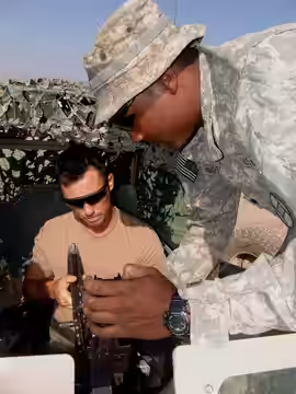 Spc. Parnell Richardson, of Wilson, N.C., shows Jeffrey Donovan an M-240-B machine gun, Nov. 13. A morale, welfare and recreation tour brought Donovan and fello (2009)