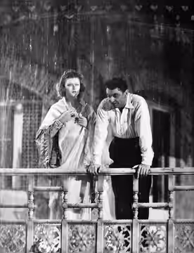 Photograph of Myrna Loy and George Brent in The Rains Came (1939)