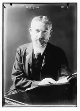 Title: G.B. Shaw at desk with book Abstract/medium: 1 negative : glass ; 5 x 7 in. or smaller.