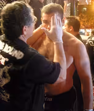 Cutman Jacob "Stitch" Duran prepares Gabriel "Napão" Gonzaga for a match by applying petroleum jelly to his face.