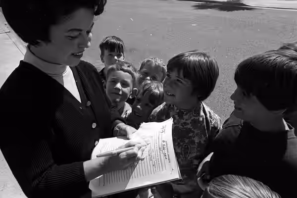 Shirley Temple Black signing autographs for children in Los Angeles Original caption: "SIGNS AUTOGRAPHS—Youngsters happily crowd around to get a prized autograp (1967)