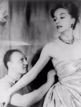Fashion designer Pierre Balmain fitting haute couture gown on actress Ruth Ford. Photographed by Carl Van Vechten, on 9 November 1947.