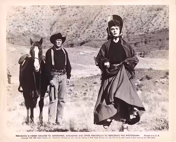 Publicity poster for the film Wagon Master (1950) showing Ben Johnson (as Travis) and Joanne Dru (as Denver). Denver is running away from Travis, who has just p