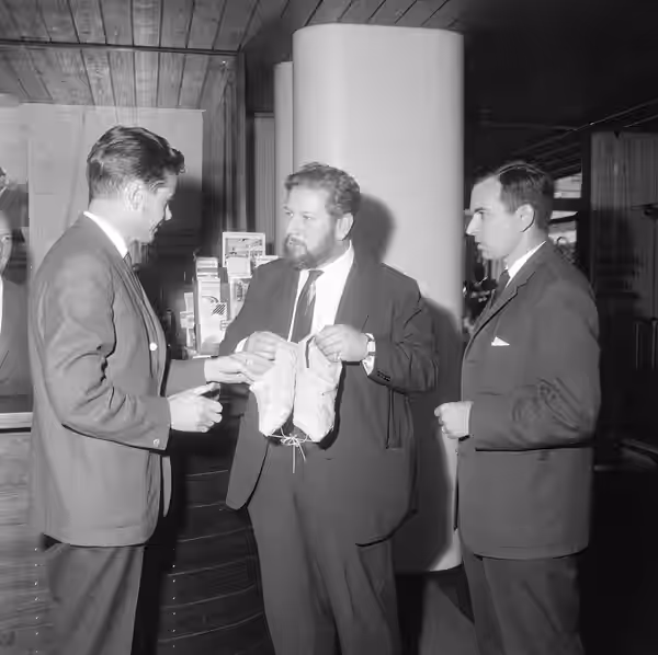 CEO of Tesvisio Väinö J Nurmimaa, british actor Peter Ustinov and director Matti Elo. Tesvisio's guest Peter Ustinov receives birch-bark shoes.