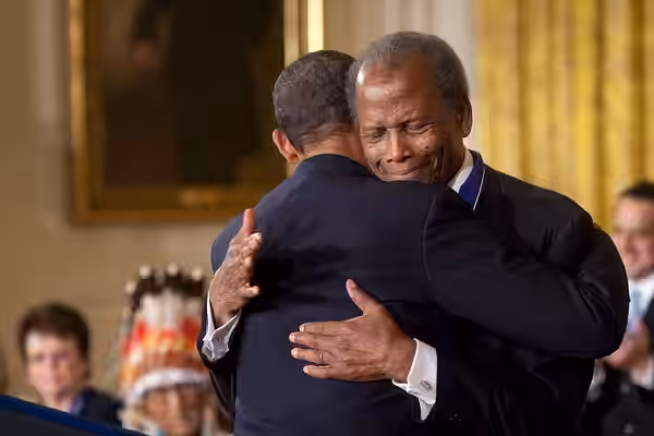 President Barack Obama hugs Presidential Medal of Freedom recipient actor Sidney Poitier during the award ceremony in the East Room of the White House, on Aug. 