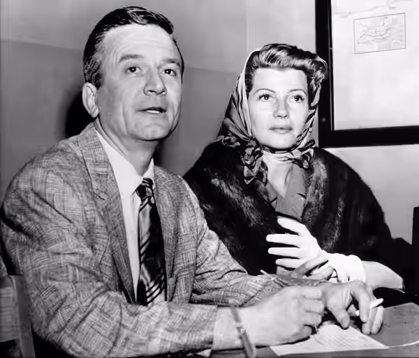 Photograph of Rita Hayworth and James Hill obtaining their marriage license Caption on photograph run in the Cedar Rapids Gazette reads as follows: RITA GETS A  (1958)