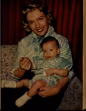 A color photo of Joan O'Brien holding her son, Rusty. Published in TV Radio Mirror, July 1956.