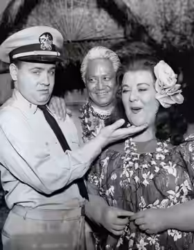 Photo of Tim Conway, Leon Lontok and Peggy Mondo from the television program McHale's Navy. The chief's (Lontok) daughter, Little Flower (Mondo) has fallen head (1963)