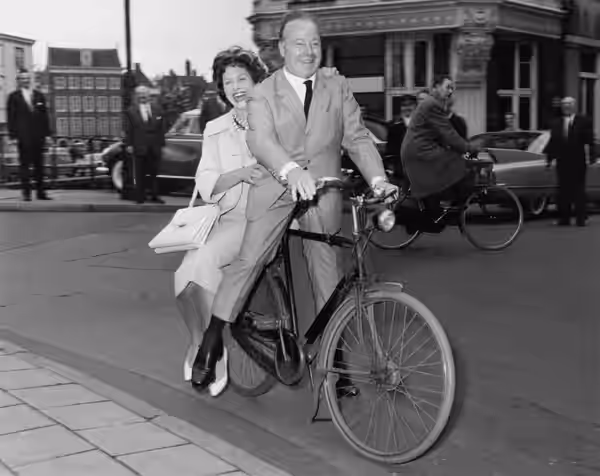 Duitse film-acteur Heinz Rühmann op een fiets, Nieuwe Doelenstraat, 13 maart 1960 Foto Ben van Meerendonk / AHF, collectie IISG, Amsterdam