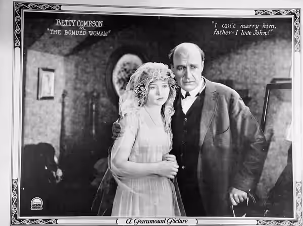 Lobby card for the American drama film The Bonded Woman (1922). Pictured are Betty Compson and J. Farrell MacDonald.