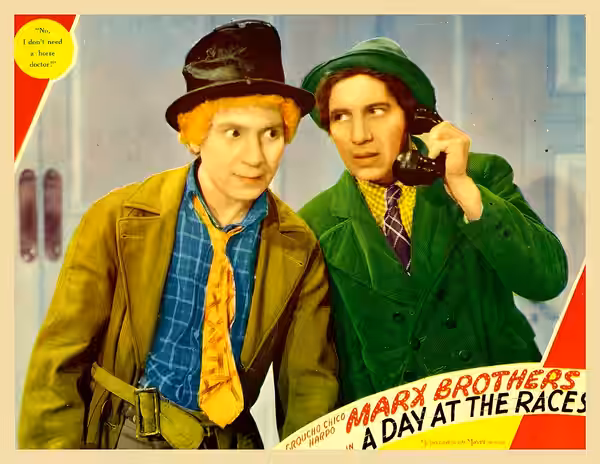 Colored lobby card for the 1937 film A Day at the Races. Pictured: Harpo and Chico Marx. Image is assumed to be in the public domain as no copyright notice is i