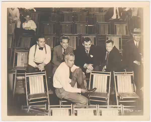 Howard Hawks, front, with other film people. The back of the photo has "Hearts in Exile (1929)" in pencil, but this may not be accurate. It may depict people in