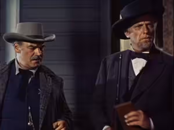 Ray Teal and Howard Petrie in Rage at Dawn- cropped screenshot. This film is in the public domain now. (1955)