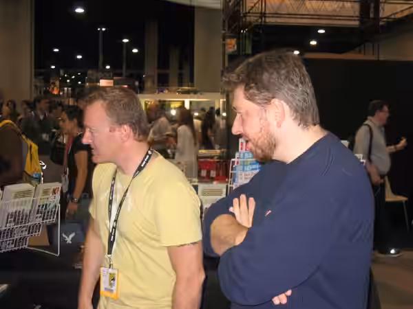 Mike and John strategize the best way to entice the half-naked Furry that wandered over to our booth to come over and say, "hi." (2007)