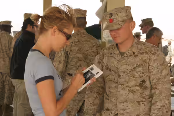 Ali Al Salem, KW - Traylor Howard autographs her picture for a Marine at Ali Al Salem. (2005)