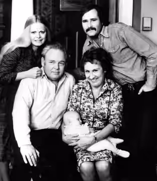 Photo of the Cast of the television program All in the Family. Standing are Sally Struthers (Gloria) and Rob Reiner (Michael); seated are Archie (Carroll O'Conn