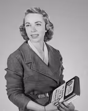 Dr. Joyce Brothers, half-length portrait, facing slightly left, holding book she wrote / World Telegram photo by Phyllis Twacht (1957)