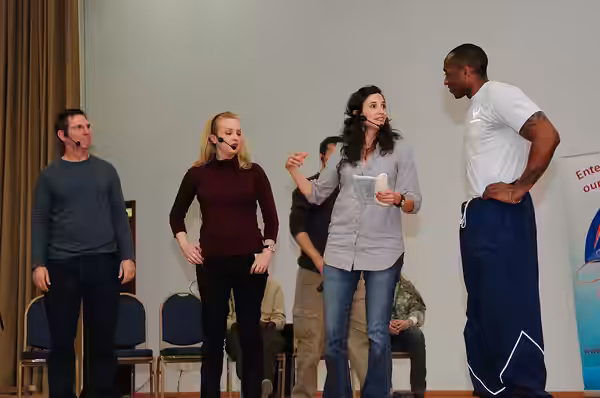 Senior Airman George Minkins, 386th Expeditionary Contracting Squadron, participates in an improv comedy skit with comedians (from left to right) Tim Bagley, We
