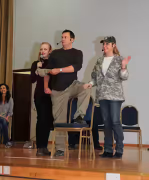Comedians (from left to right) Wendy McLendon, Michael Hitchcock and Karri Turner perform a mock American Forces Network holiday greeting during a show for mili
