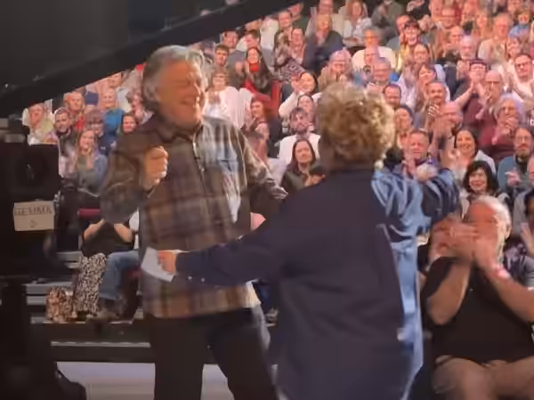 Alan Davies and Sandi Toksvig on set of QI hugging 2025