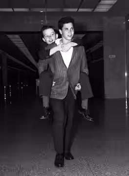 SAVING MONEY—Jerry Mathers, 10, better known as Little Beaver, rides out of courtroom on the back of his TV show brother, Tony Dow, 13, after they had discussed (1959)