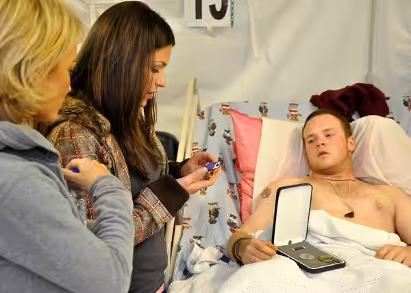KANDAHAR AIRFIELD, Afghanistan - Celebrities Kelly Carlson and DeAnna Pappas examine a Purple Heart Medal belonging to wounded Soldier Sgt. Scott Mackay; a Stra (2009)