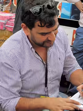 El historietista y guionista chileno Pedro Peirano dando un autógrafo en la Feria Internacional del Libro de Santiago 2015