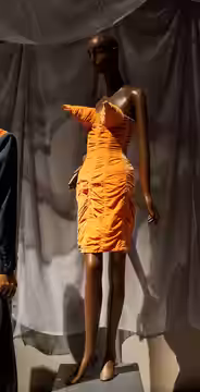 Orange cone-bra dress, fall 1984, by Jean Paul GaultierDress, Dreams and Desire at FIT (2025)