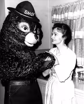 Smokey Bear and Actress June Lockhart from the “Lassie” TV Show. Lassie is an American television series that follows the adventures of a female Rough Collie do