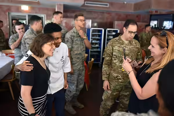 Mayim Bialik poses for a photograph with a service member, Rheinland Dining Facility, Ramstein Air Base, Ramstein-Miesenbach, Germany, July 3, 2019. Air Force G