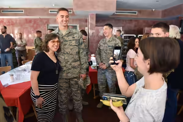 Mayim Bialik poses for a photograph with a service member, Rheinland Dining Facility, Ramstein Air Base, Ramstein-Miesenbach, Germany, July 3, 2019. Air Force G