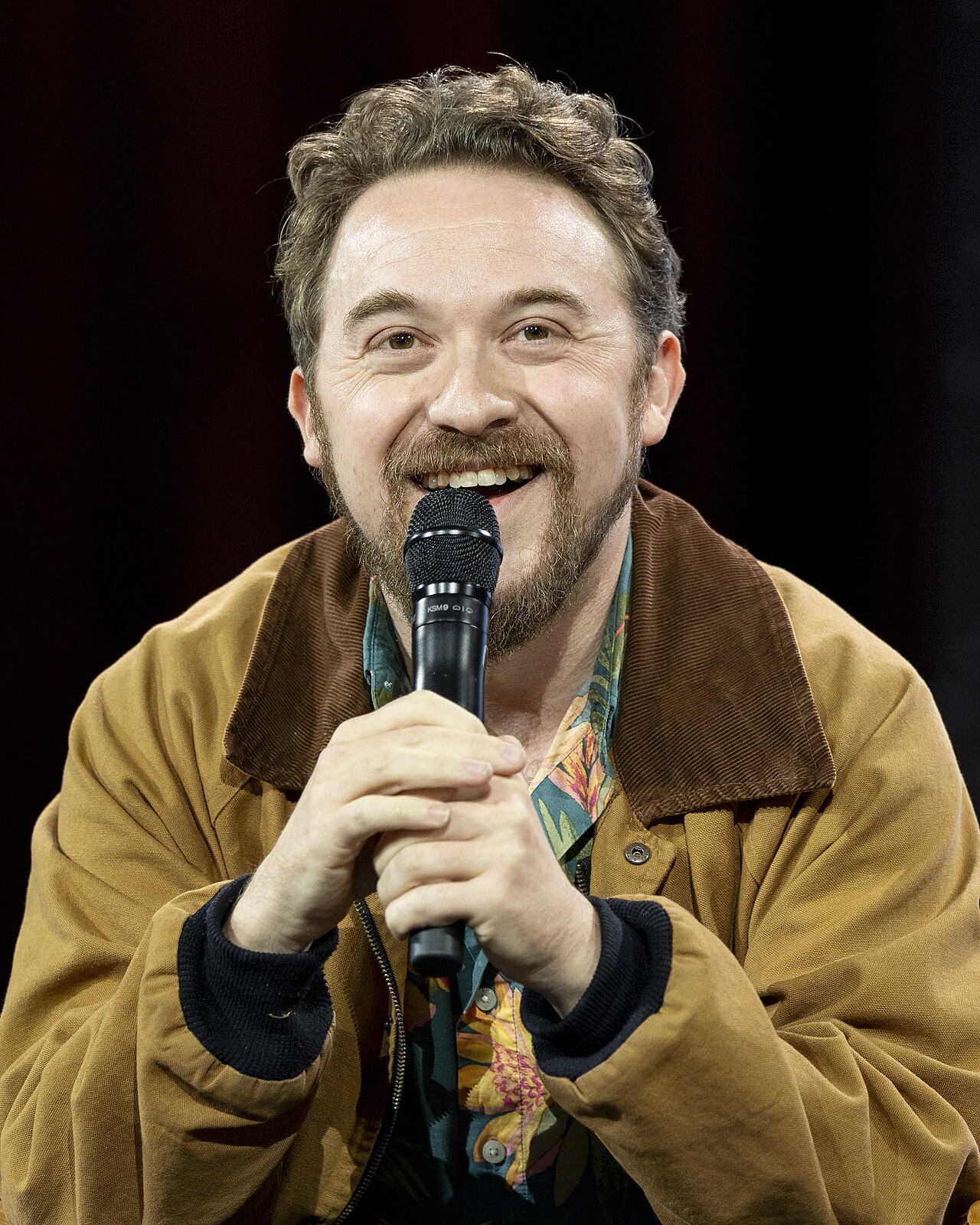 Alex Hirsch seated onstage during “Fireside Chat: Alex Hirsch × TheOdd1sOut” at Open Sauce 2026.