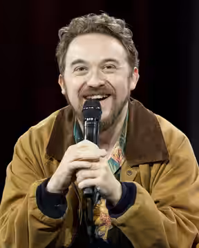 Alex Hirsch seated onstage during “Fireside Chat: Alex Hirsch × TheOdd1sOut” at Open Sauce 2026.