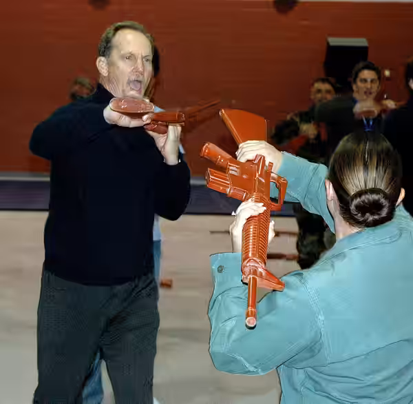 Actor Michael O'Neill practices some self-defense tactics with instructor Rhonda Battles using an M-16 training aid while visiting Lackland Air Force Base, Texa (2006)
