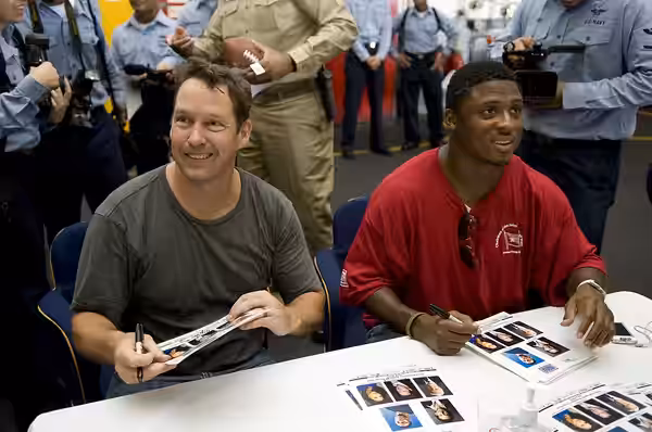 GULF OF OMAN (July 13, 2009) D.B. Sweeney and All-Pro NFL running back Warrick Dunn sign autographs aboard the aircraft carrier USS Ronald Reagan (CVN 76) aboar