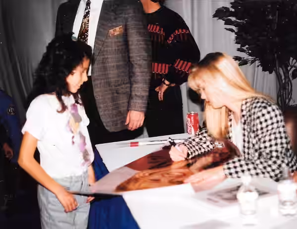 Jennie Garth signing a poster of Kelly for a young fan at a mall in New Jersey (1993)