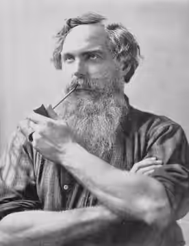 Portrait of actor Burr McIntosh, in character with a full beard, smoking a pipe