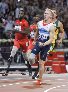 JONNIE PEACOCK (GBR) (R) claims victory for first place with BLAKE LEEPER (USA) (L) just behind in the men's 100m T44 at the 2012 Paralympic Games.
