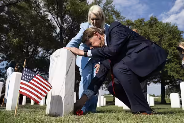 Prince Harry speaks with Mark and Karen Zook at the gravesite of their son, U.S. Marine Corps Ian Zook, in Section 60 of Arlington National Cemetery, Arlington,