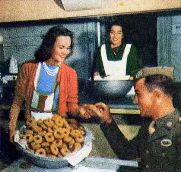 Photograph of Elizabeth Inglis (left) working at the Stage Door Canteen in New York City. Photograph appears within the feature "Life Goes to the Stage Door Can (1944)