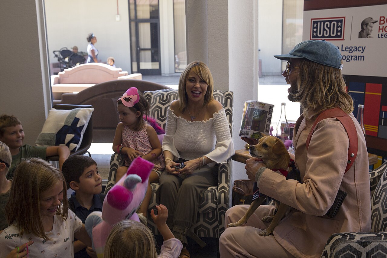 Tara Strong, center, and Greg Cipes, both voice actors, laugh with the children during the United Service Organization story party event at the USO building on  (2019)
